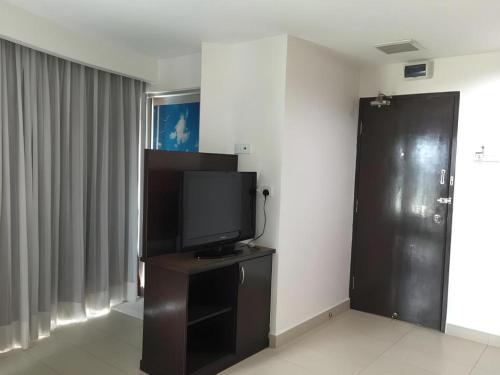 a room with a television on a stand with a door at Loong Fatt Hotel in Sungkai