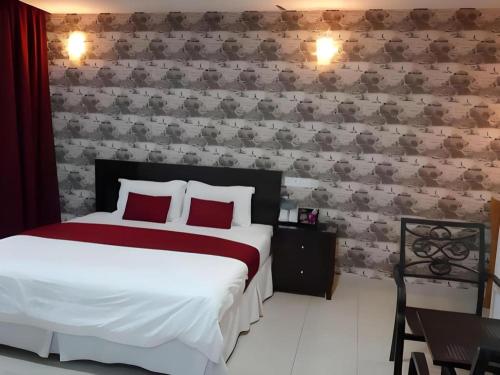 a bedroom with a large bed with red pillows at Loong Fatt Hotel in Sungkai
