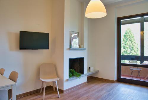 a living room with a fireplace and a flat screen tv at CaLolden in Ballabio