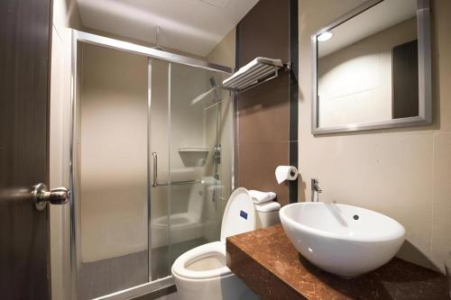 a bathroom with a sink and a toilet and a shower at Aston Boutec Hotel Lintas Plaza in Kampong Nasob