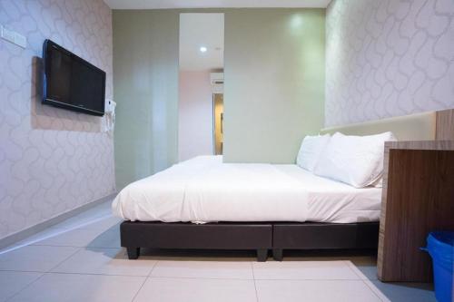 a bedroom with a bed and a flat screen tv at Cappuccino Hotel @ Mount Austin in Johor Bahru