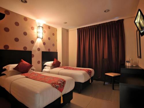 a hotel room with two beds and a window at Sea Lion Hotel @ Klang in Klang
