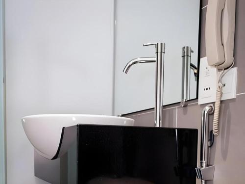 a bathroom with a sink and a phone at Mornington Hotel Medan Ipoh in Kampong Simee