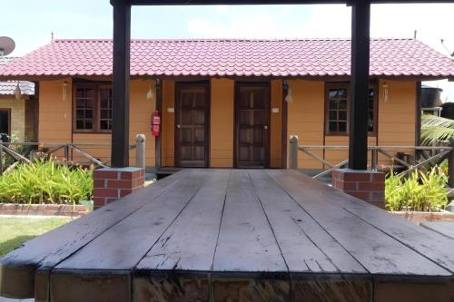 a wooden table in front of a house at MyDesaStay in Sekincan