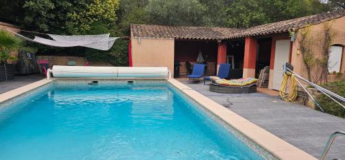 ein Pool mit einer Bank neben einem Haus in der Unterkunft Appartement à La Bastidonne in La Bastidonne