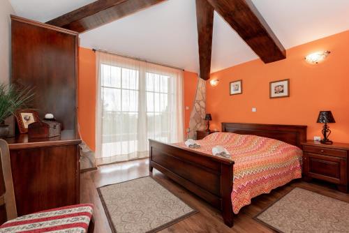 1 dormitorio con paredes de color naranja, 1 cama y ventana en Villa Ivona, a luxurious villa minutes from the sea, en Labin
