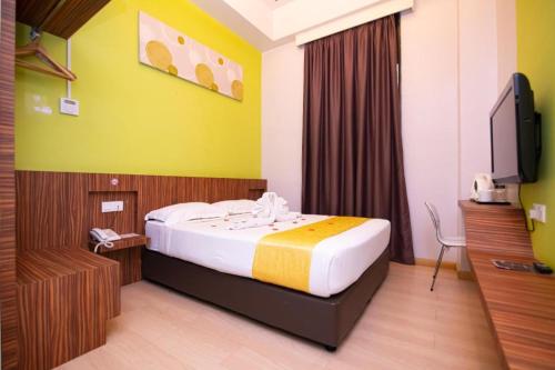 a hotel room with a bed and a flat screen tv at Sri Manja Boutique Hotel in Kuantan