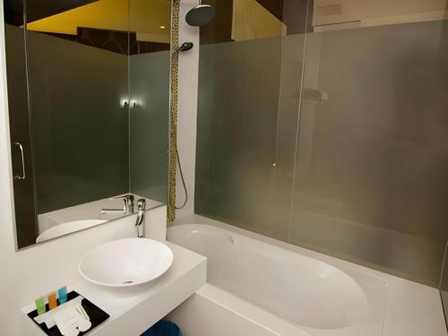 a bathroom with a sink and a toilet and a mirror at Sri Manja Boutique Hotel in Kuantan