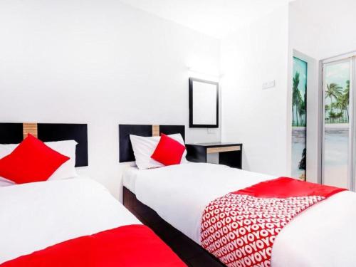 マラッカにあるHotel Bao Shuの赤と白の枕が備わるベッド2台(1室あたり)