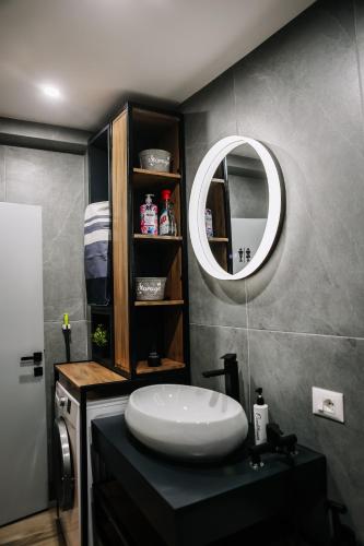 a bathroom with a sink and a mirror at Karma Chic&Style Intera Villa in Korçë