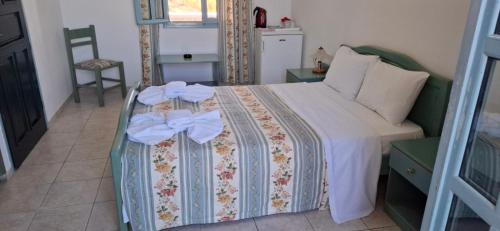 a bedroom with a bed with bows on it at Izabella Studios Apartments in Pitsidia