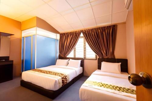 um quarto com duas camas e uma janela em RAINFOREST Budget Stay em Kuching