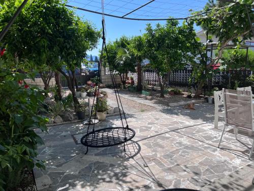 a swing in the middle of a patio with trees at Villa Mandarin in Opuzen