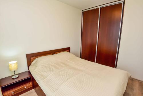 a bedroom with a bed and a wooden cabinet at Bears Apartments in Palanga
