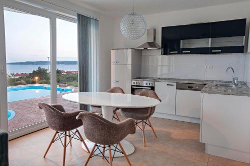 a kitchen with a table and chairs and a pool at Villa Pia Split in Kaštela