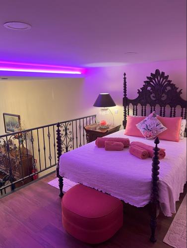 a bedroom with a large bed with purple lighting at Grand Studio 56 in Faro