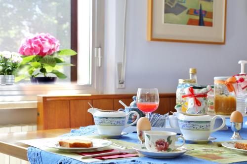 a table with a tea set with a glass of wine at Al Villino del Sole in Fano