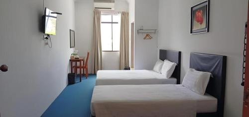 a hotel room with two beds and a table at OYO 90785 Pandan Hotel in Kota Kinabalu