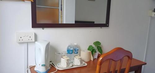 a table with a hair dryer and a chair on it at OYO 90785 Pandan Hotel in Kota Kinabalu