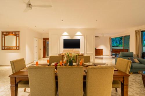 a living room with a wooden table and chairs at 5-BHK Villa With Common Pool & Lift Near Beaches in Majorda