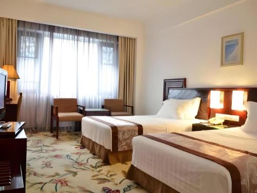 a hotel room with two beds and a window at Hong Ye Hotel in Guangzhou