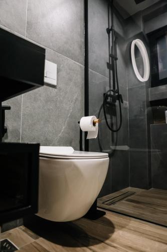 a bathroom with a white toilet and a shower at Karma Chic&Style Intera Villa in Korçë