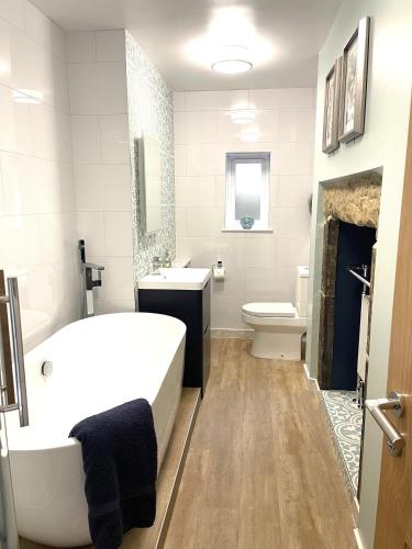 a bathroom with a tub and a sink and a toilet at Weavers Rest - New Boutique Retreat in Central Skipton with Parking in Skipton