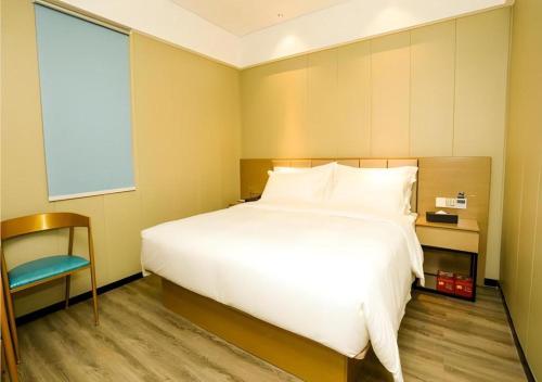 a bedroom with a large white bed and a window at Borrman Hotel Xiamen Xiang'an Maxiang in Xiamen
