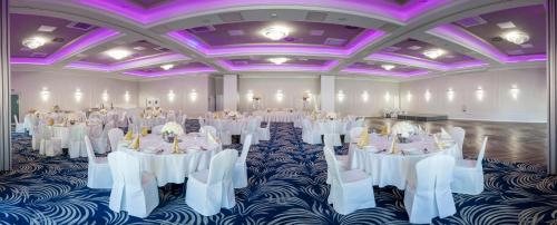 a banquet hall with white tables and purple ceilings at Hotel Sękowski in Legnica