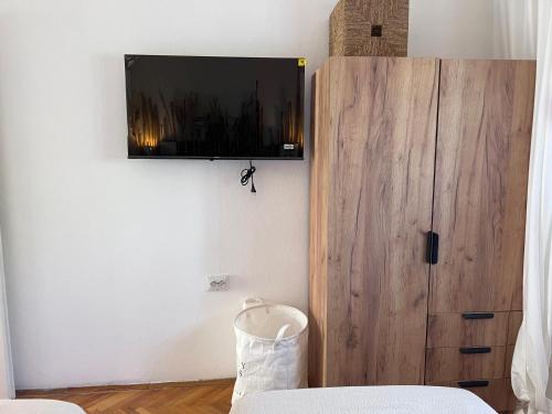 a room with a tv and a wooden cabinet at Villa Mandarin in Opuzen