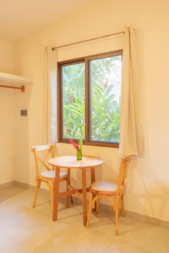 a table and two chairs in a room with a window at Casa Cactus Buenavista in Bacalar