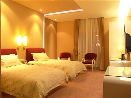 a hotel room with two beds and a mirror at Tomolo Hotel Wuzhan Branch in Wuhan