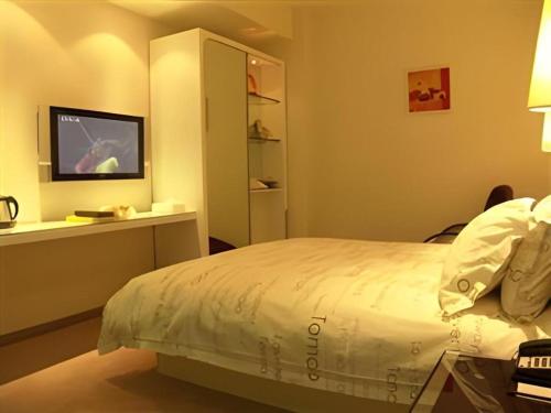 Кровать или кровати в номере Tomolo Hotel Wuzhan Branch