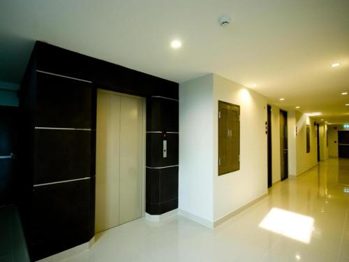 a hallway with black doors and white walls at Pannapat Place in Bangkok