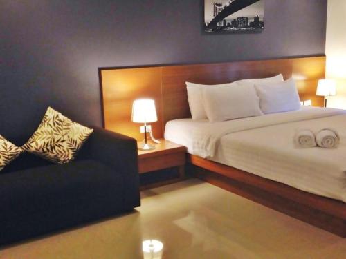 a hotel room with a bed and a couch at Pannapat Place in Bangkok