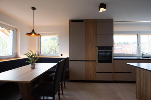 a kitchen with a wooden table and a refrigerator at Alpenglow Apartments in Collalbo