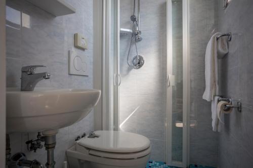 a bathroom with a toilet and a sink and a shower at Costa del Sole Only Room in Milano Marittima