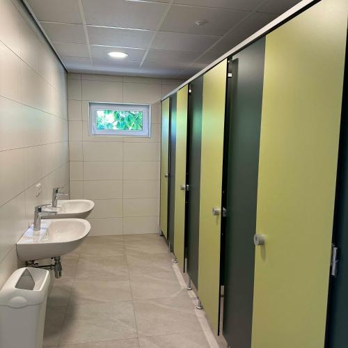 a bathroom with two toilets and a sink at Empty camping spot for your tent, caravan and camper in Swalmen