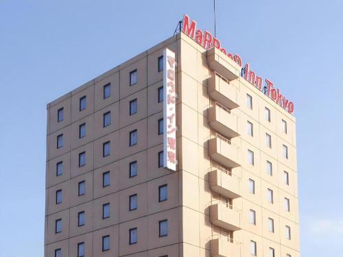 a building with a sign on the top of it at Marroad Inn Tokyo in Chofu