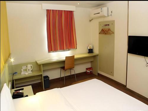 a room with a bed and a desk and a window at 7 Days Inn Guilin Beiji Plaza Yushan Garden in Guilin