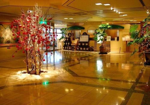 a lobby with two palm trees and christmas decorations at Hotel Castle Plaza in Kobe