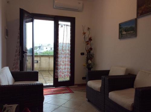 a living room with chairs and a sliding glass door at Villa Matine in Specchia