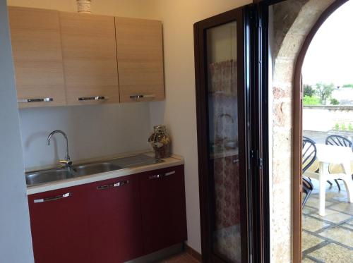 a kitchen with a sink and a door to a patio at Villa Matine in Specchia