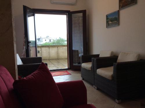 a living room with chairs and a sliding glass door at Villa Matine in Specchia
