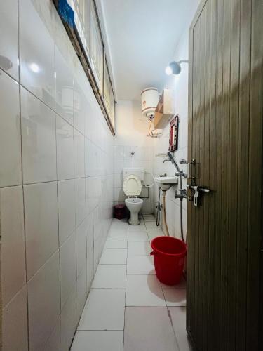 a bathroom with a toilet and a sink and a door at MONALISA HOSTEL in Varanasi