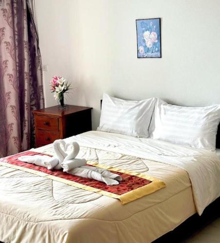 a bedroom with a bed with a towel on it at Rueangrat Hotel in Ranong