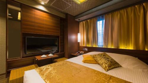 a bedroom with a large bed and a television at Hotel Ann Tsukiji in Tokyo