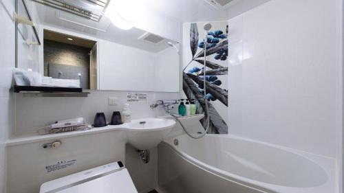 a white bathroom with a sink and a mirror at Hotel Ann Tsukiji in Tokyo
