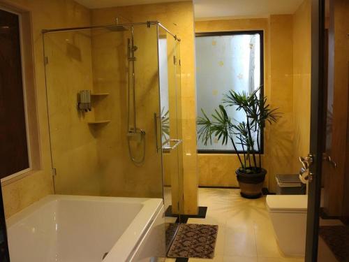 a bathroom with a tub and a shower and a toilet at Maleewana Hotel & Resort in Bang Yai