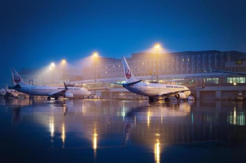 three airplanes parked at an airport at night at Air Terminal Hotel in Chitose